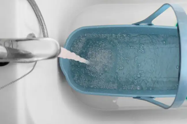 Using a bucket to collect greywater in a bathtub
