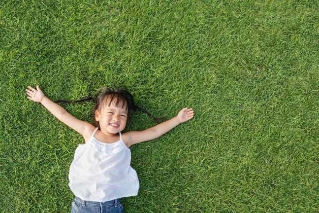 Littel Girl Laying On Lawn Grass